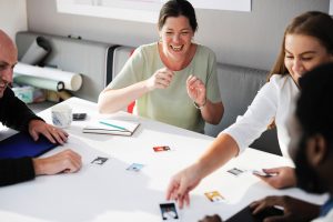 woman laughs as she discusses work in meeting with colleagues